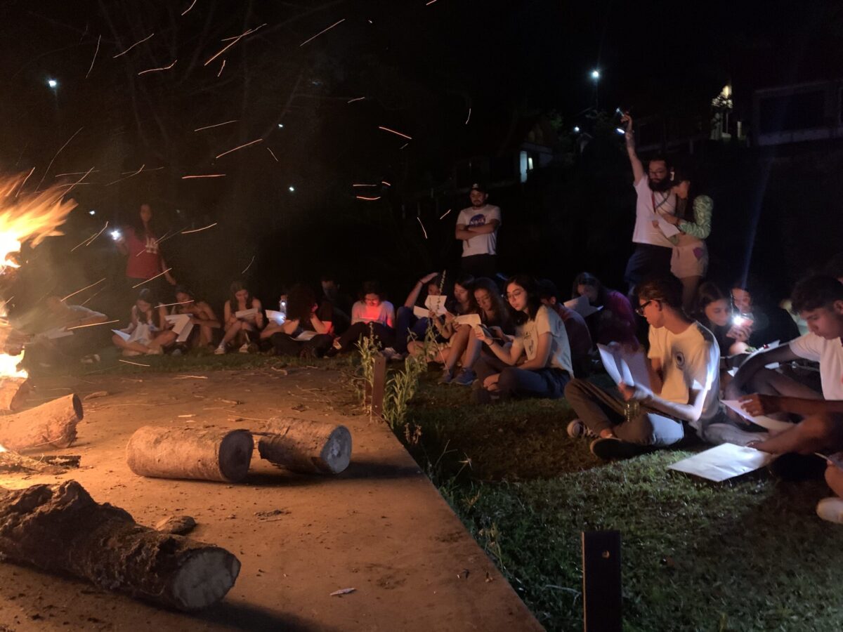 Grupo reunido al aire libre junto a una fogata